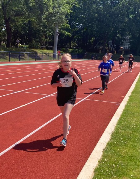 Bild von Sch&uuml;lerin beim Lauf-Wettkampf auf einer Leichtathletik Laufbahn.
