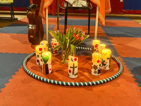 Bild von gestalteten Kerzen, die mit einem Strauß Blumen innerhalb eines Ringes stehen.