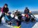 Bild von 6 Personen. 3 sitzen in Bi-Ski-Geräten, 3 stehen dahinter.