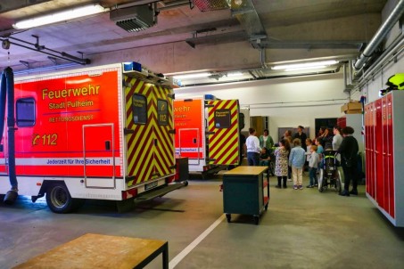 Bild von Schüler*innen in einer Halle in der 2 Rettungswagen stehen.