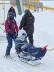 Bild von einem Skifahrer in einem Bi-Ski Gerät. Hinter ihm ist ein weiterer Skifahrer, der das Gerät steuert.
