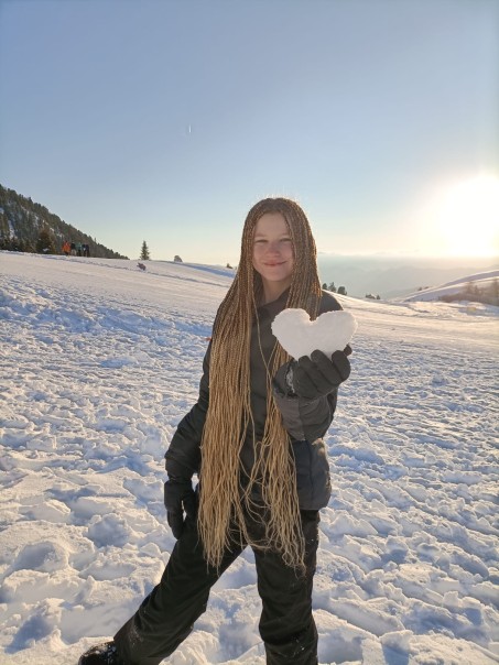 Bild von einer Schülerin die in der Hand ein Herz aus Schnee hält.