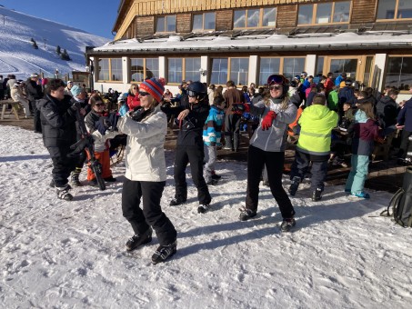 Bild von einer Personengruppe, die sich in Skibekleidung aufwärmt