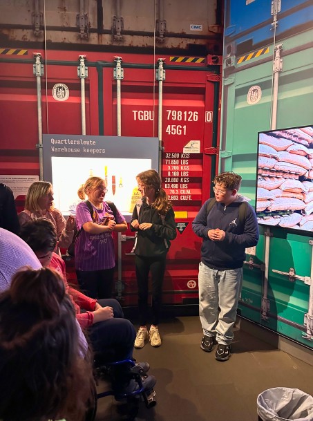 Bild von 4 Schüler*innen in der Ausstellung.