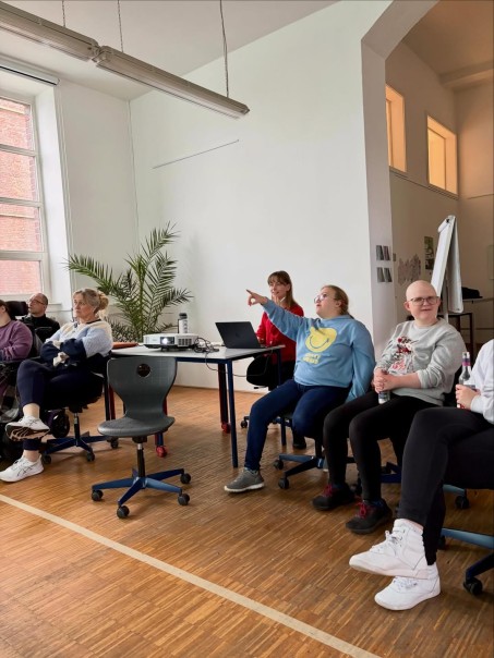 Bild von mehreren Personen, die in Richtung einer Leinwand schauen.