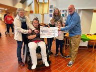 Bild von 6 Personen. Alle halten gemeinsam einen riesigen Scheck auf dem der Betrag von 3.414 € eingetragen ist.