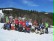 Ein Gruppenbild von Skifahrern im Schnee. Es sind Schüler mit Skiern und  Monoski zu erkennen. Dazu gehören auch Erwachsene.
